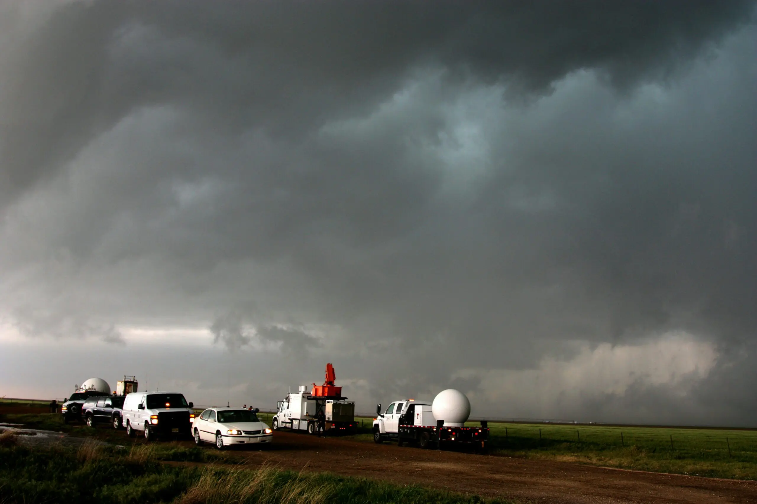 Storms in the background with weather trucks on the road taken by noaa