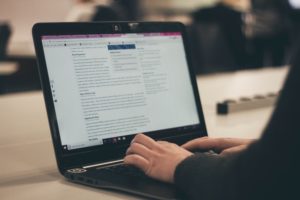 Blogger Writing on Laptop